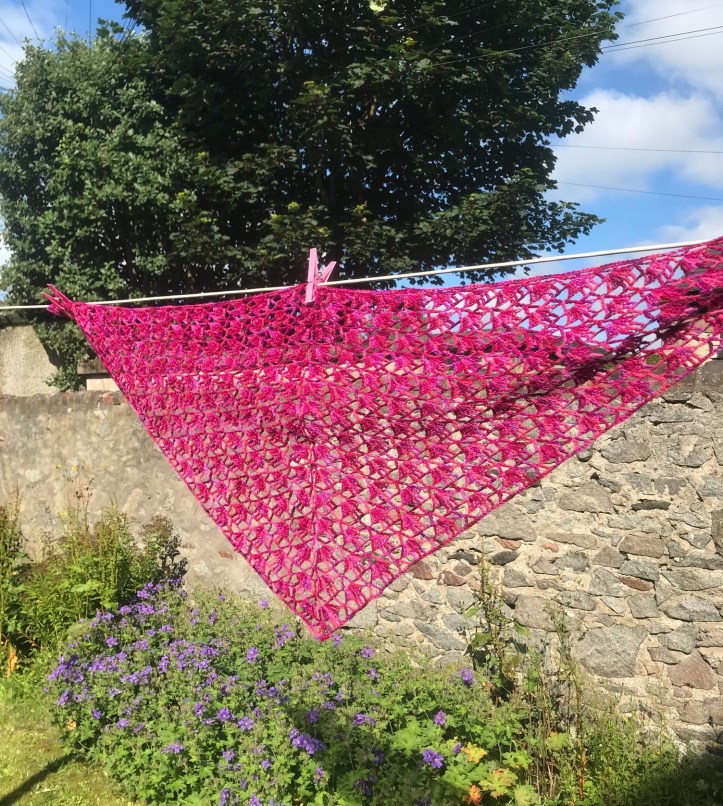 Finished crochet shawl hanging on washing line