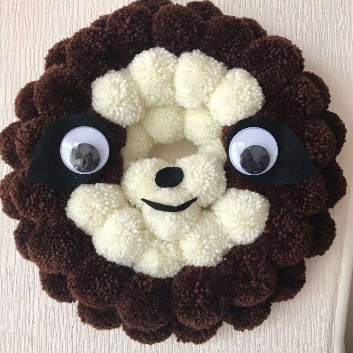 Pompom wreath designed as a sloth